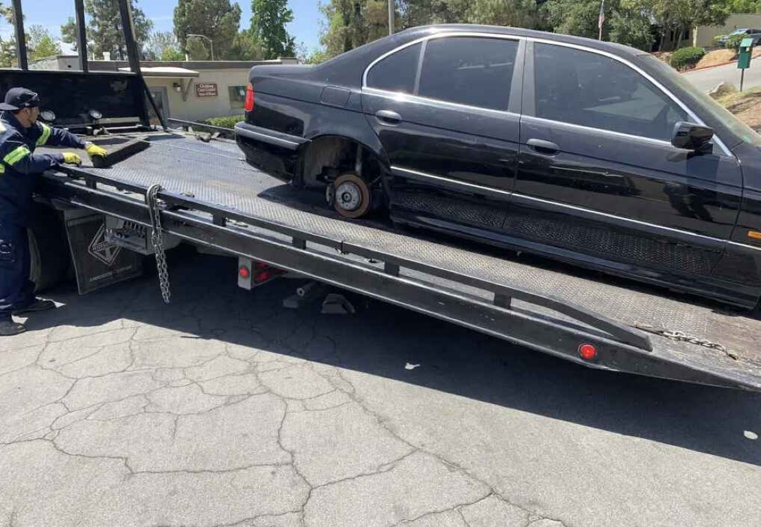 Flatbed tow truck loading vehicle for junk car removal service in Gilroy, CA