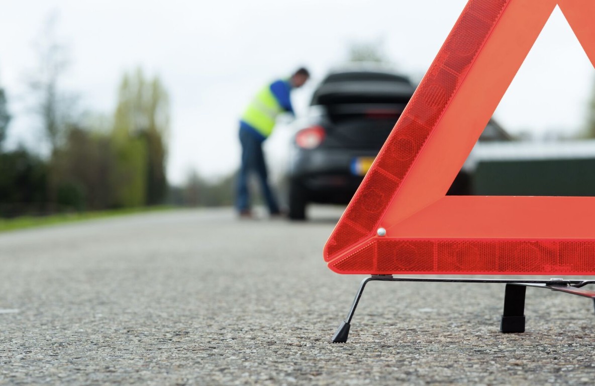 Emergency roadside assistance with warning triangle and stranded vehicle in Gilroy, CA