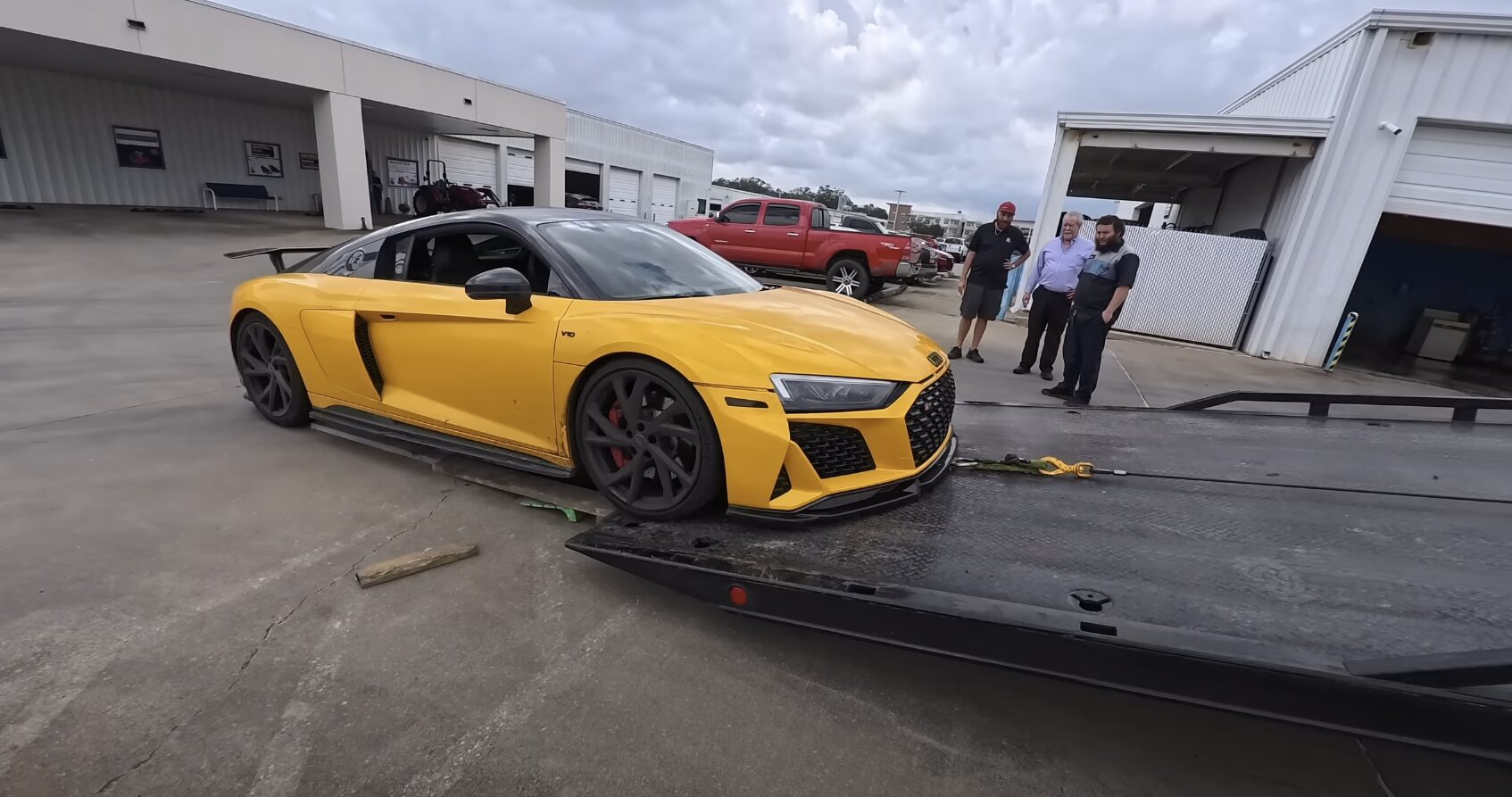 Flatbed tow truck safely transporting luxury sports car