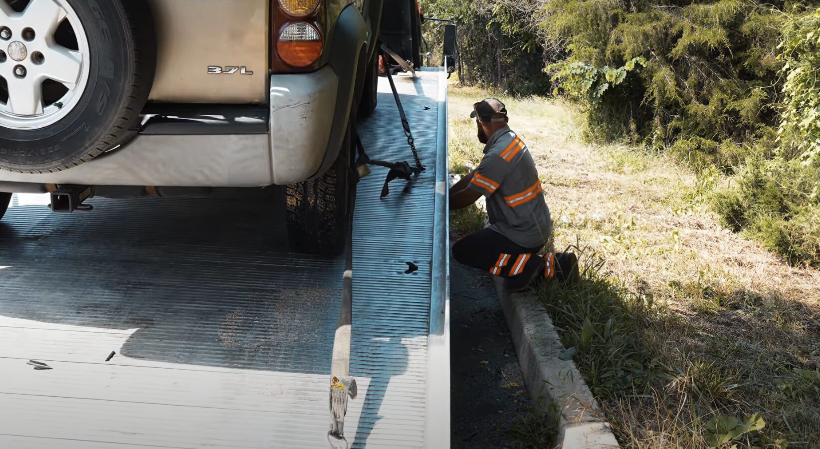 Professional tow truck operator securing vehicle during emergency towing service